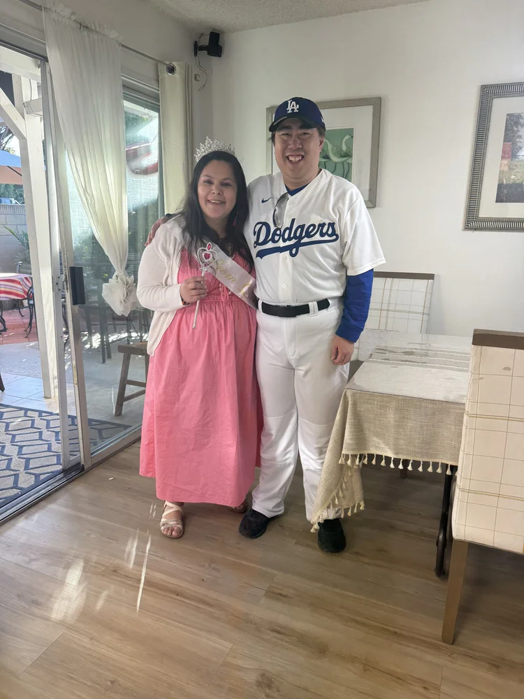 Two individuals in costume celebrating together in a bright residential living room