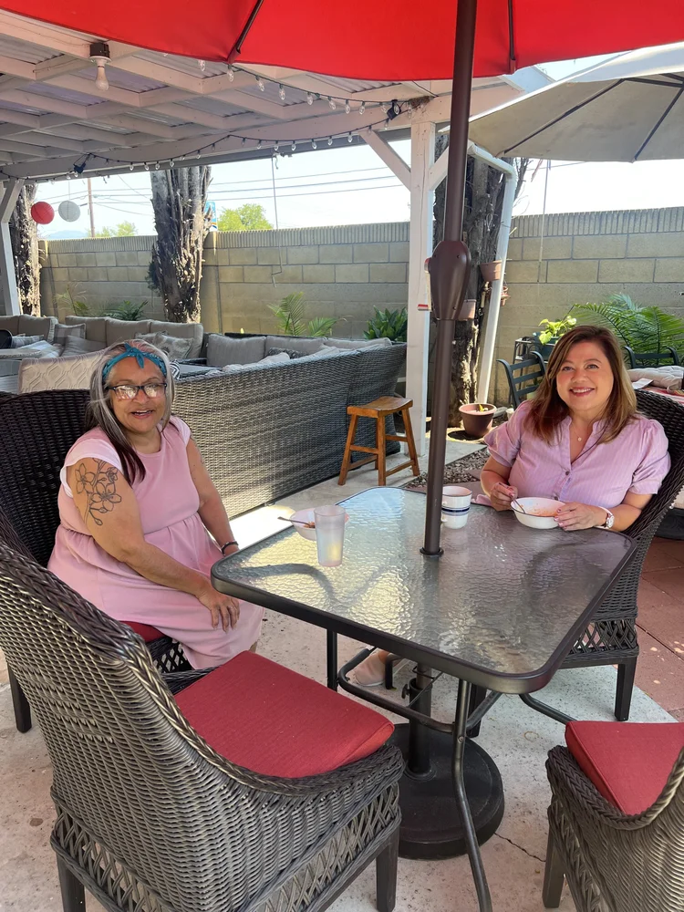 Residents enjoying a meal together on the outdoor patio with comfortable seating